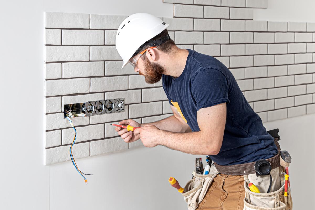 electrician-construction-worker-with-beard-overalls-installation-sockets-home-renovation-concept